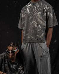 Editorial fashion composition featuring oversized charcoal mythic graphic t-shirts in a streetwear style