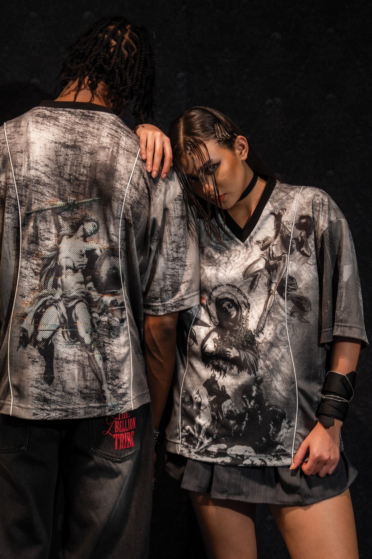 Male and female models showcasing a matching set of grey and black oversized graphic jerseys