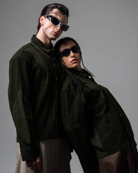 Close-up studio portrait of two models wearing dark olive textured oversized shirts