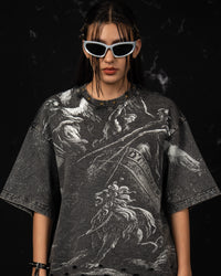 Front portrait of a woman wearing an oversized charcoal graphic t-shirt with mythic artwork