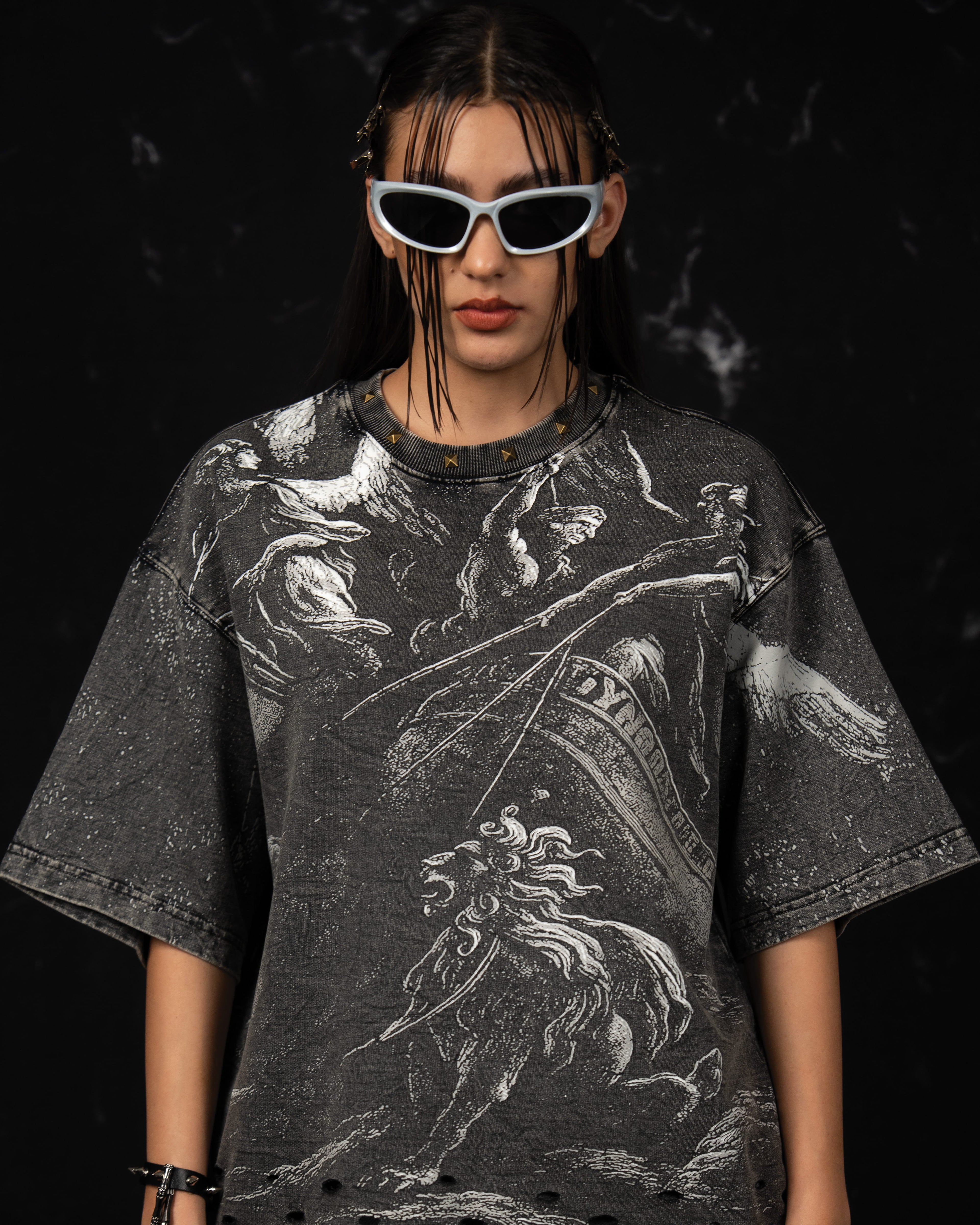 Front portrait of a woman wearing an oversized charcoal graphic t-shirt with mythic artwork