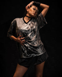 Studio fashion portrait of a woman wearing a grey and black oversized graphic jersey