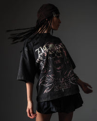 In-motion studio pose of a woman wearing a black oversized t-shirt with a premium skull print