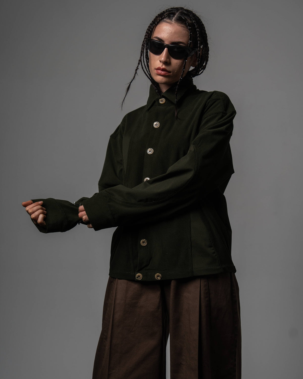 Front studio shot of a woman wearing a dark olive textured oversized shirt