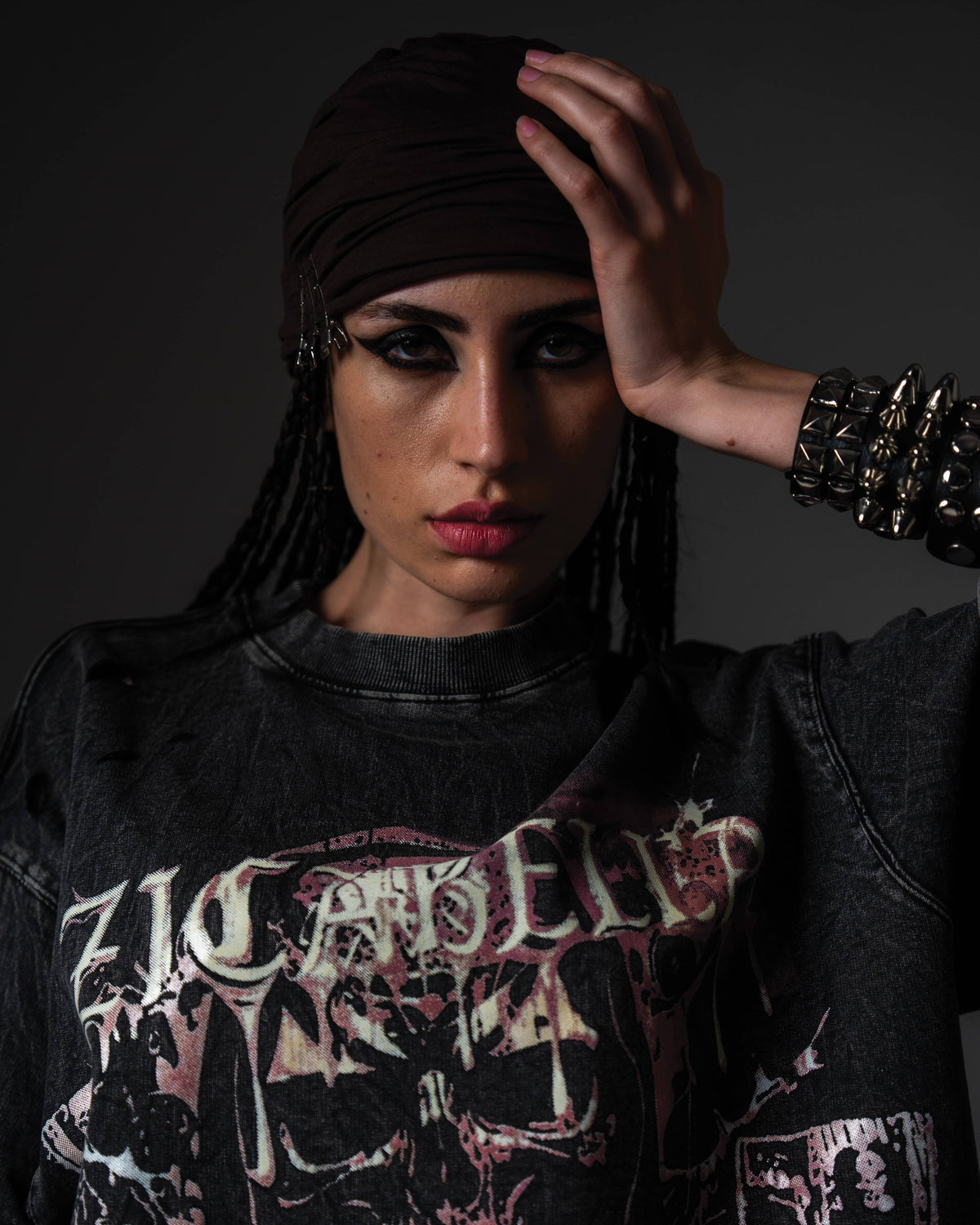 ortrait of a woman modeling an oversized black skull graphic t-shirt styled with a headscarf