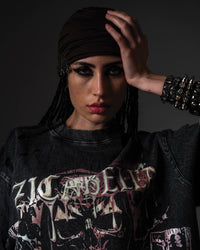 ortrait of a woman modeling an oversized black skull graphic t-shirt styled with a headscarf