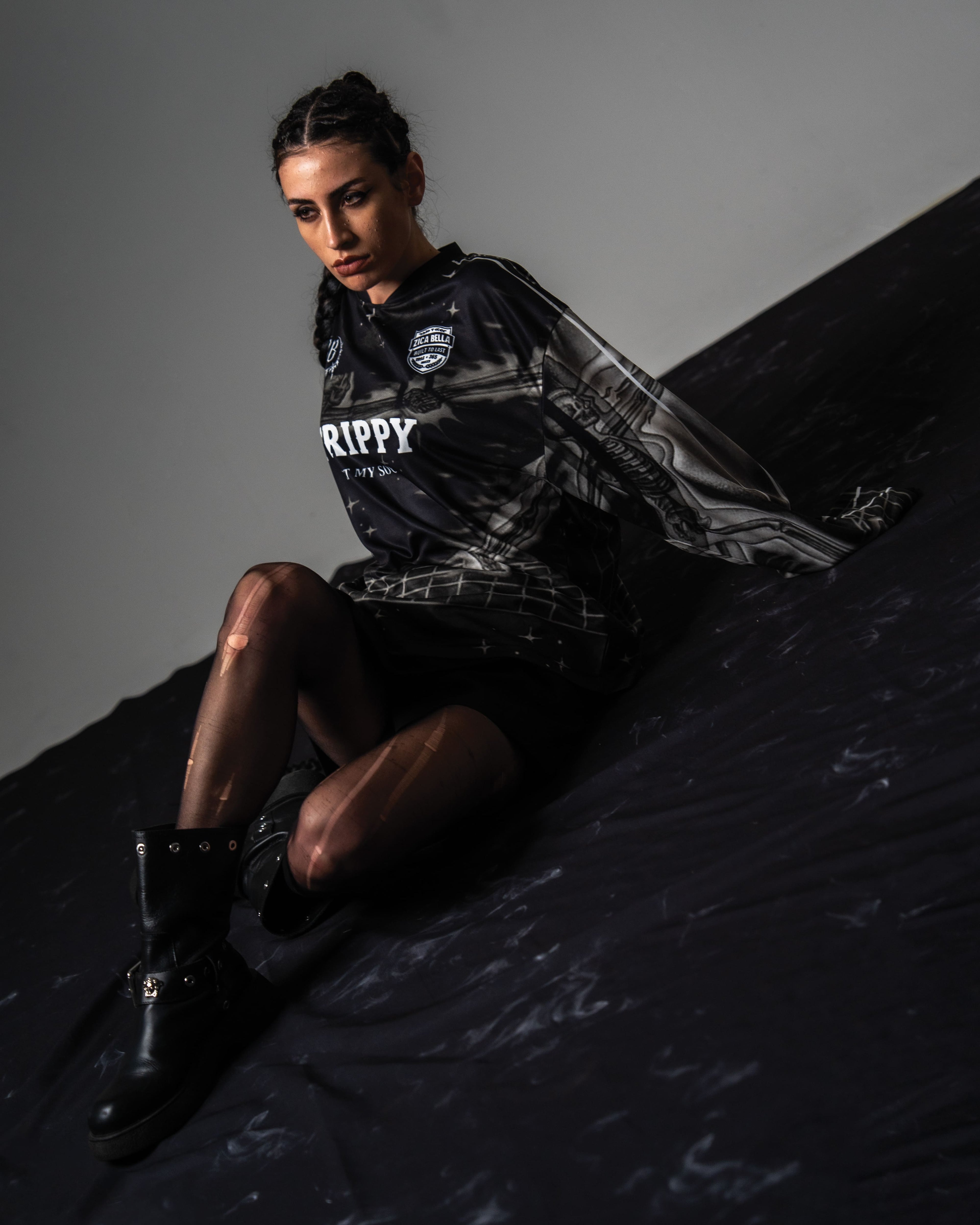 High fashion studio shot of a female model styling the oversized black TRPPY_22 streetwear jersey 