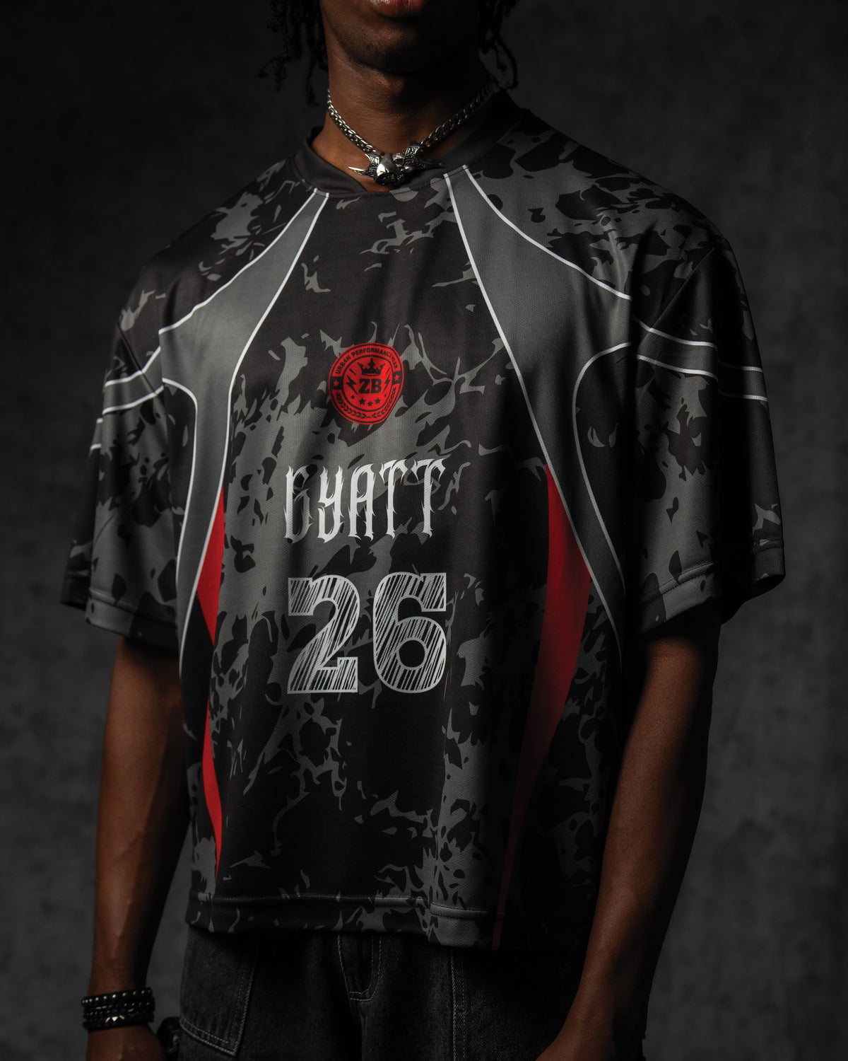 Studio side profile highlighting the seamless grey sublimation panel lines and relaxed sleeve drape on the jersey