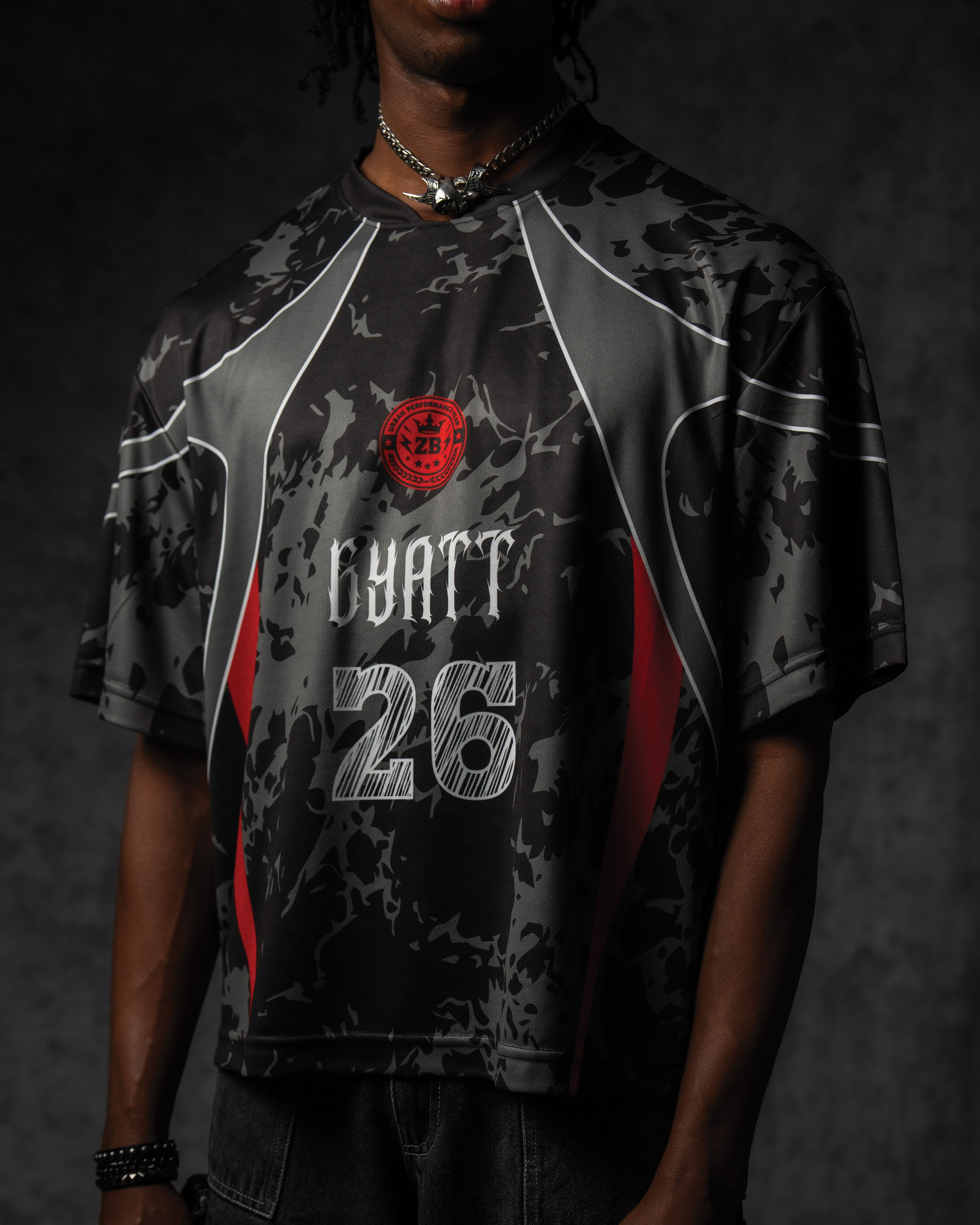 Studio side profile highlighting the seamless grey sublimation panel lines and relaxed sleeve drape on the jersey