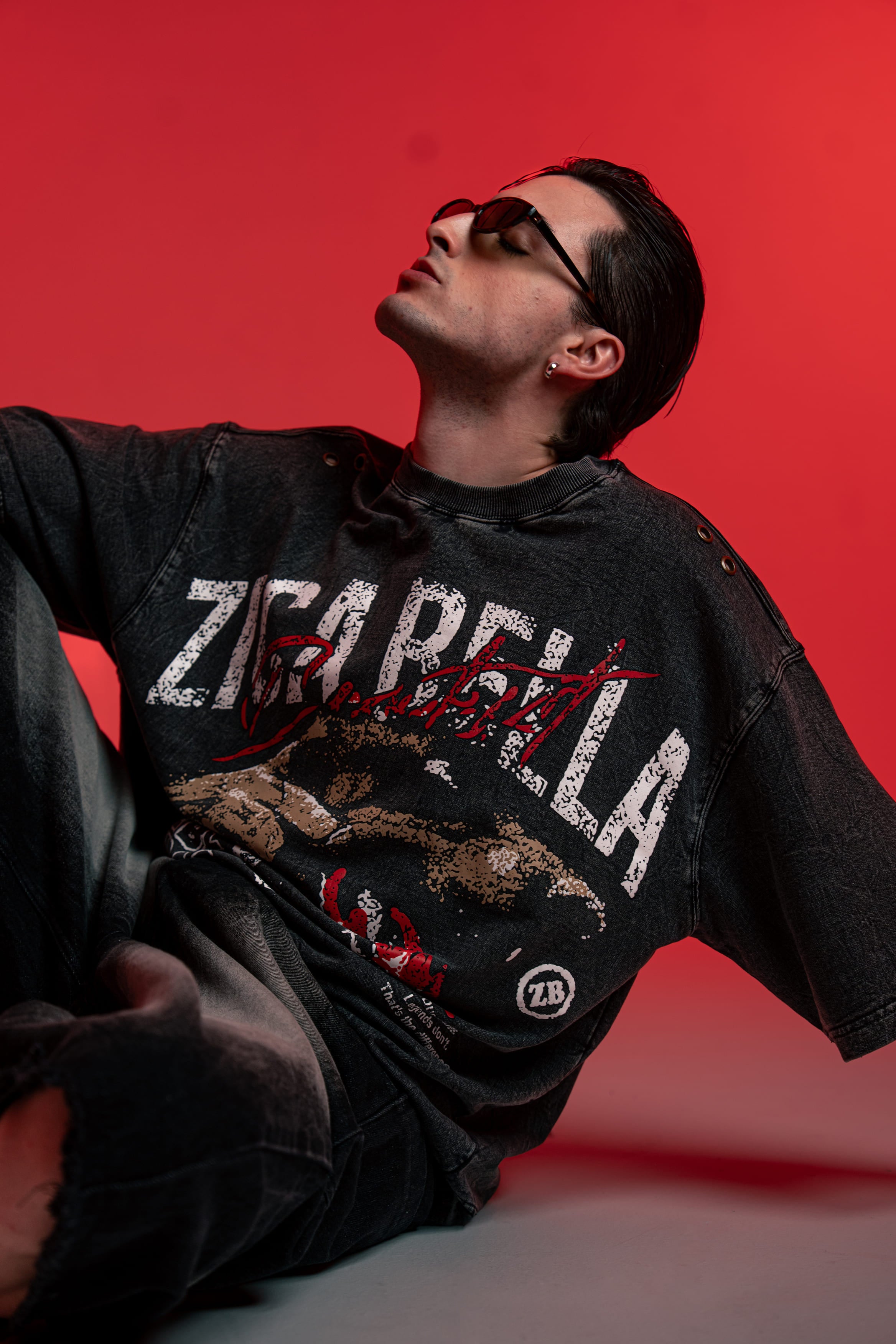ZSTRIKE oversized acid wash streetwear t-shirt styled in a modern seated lookbook pose