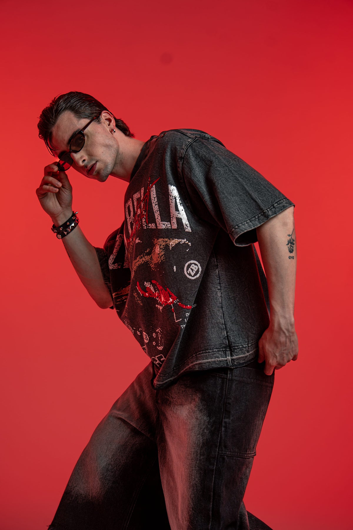 Side profile view of black washed oversized graphic tee with distressed streetwear styling