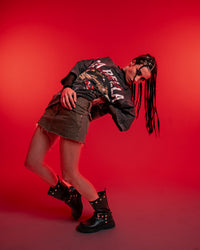 Female model in an edgy streetwear pose wearing ZSTRIKE oversized graphic tee